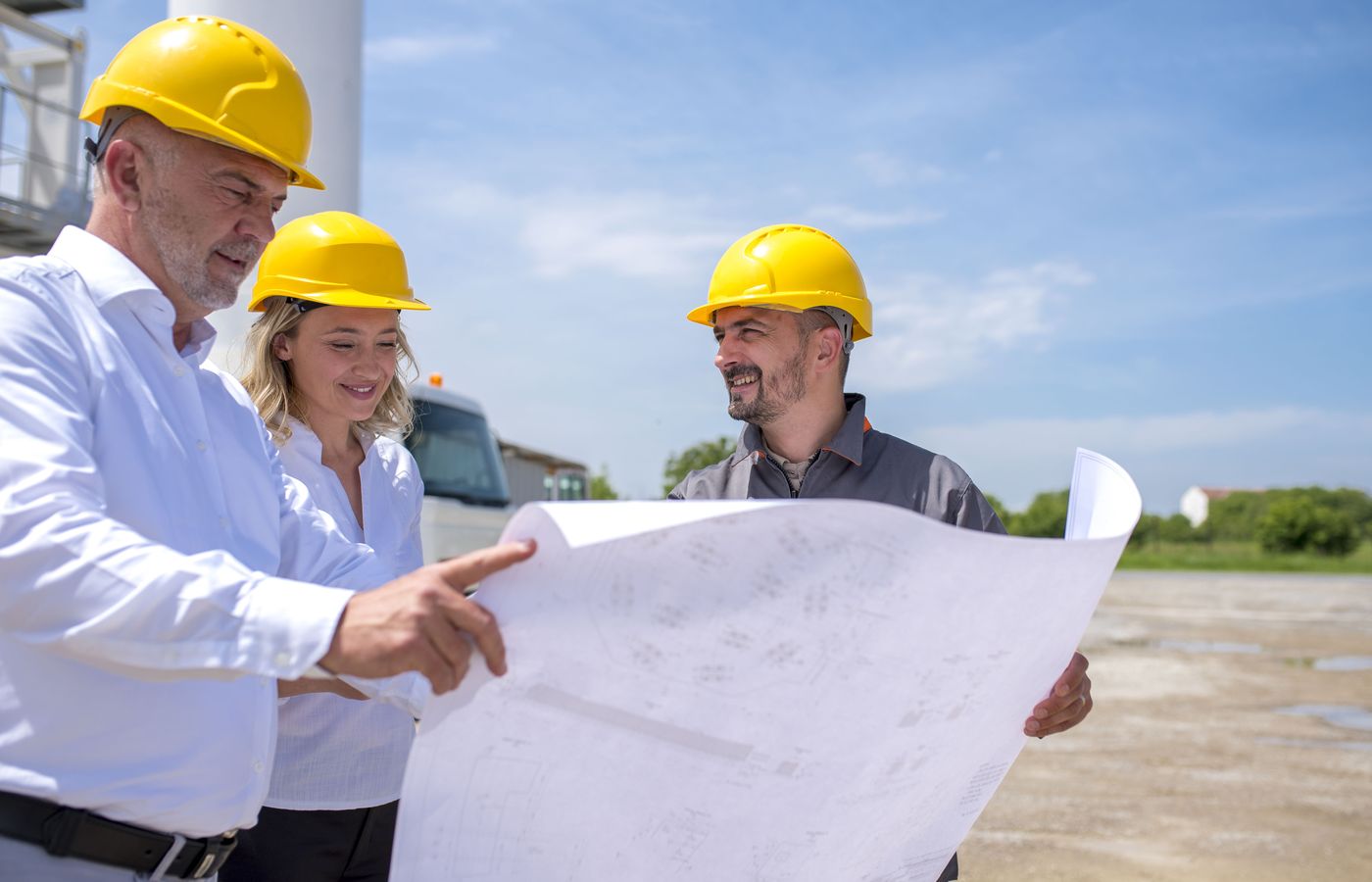 Builder walking two owners through the plans on site